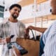 saleswoman handing bag to smiling customer at the store